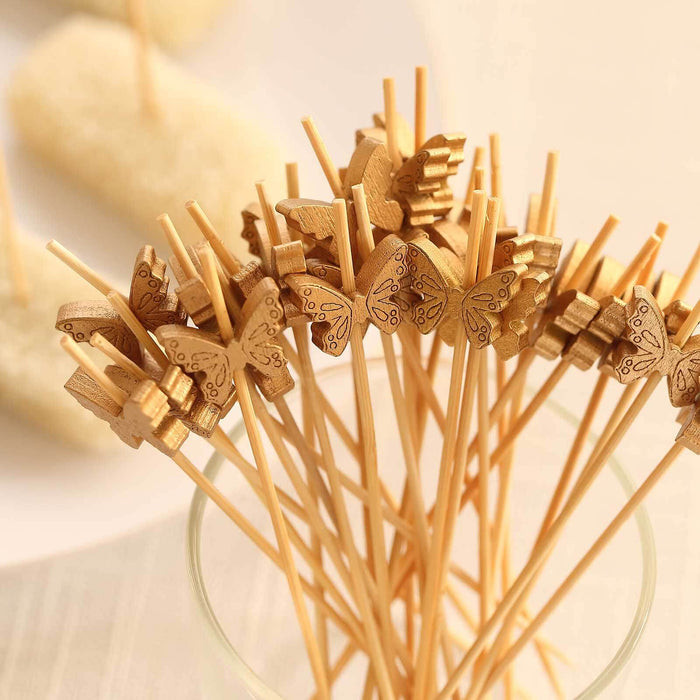 Wooden butterfly skewers in a glass vase for decoration and serving.