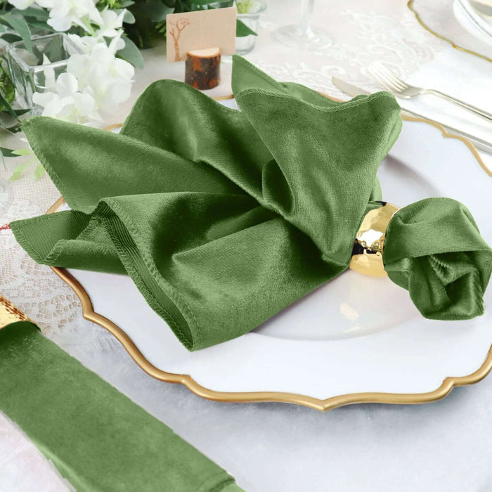 Elegant green satin napkin elegantly folded on a fine dining plate.