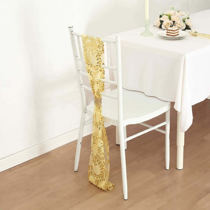 Gold decorative table scarf draped over a white chair at an elegant dining setup.