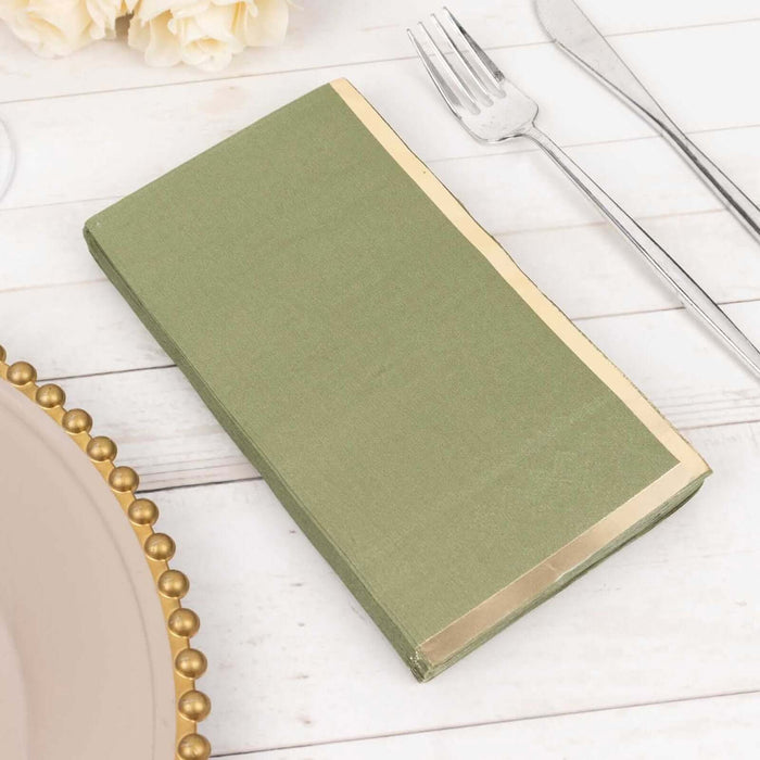 Green napkin with gold trim on a table setting.