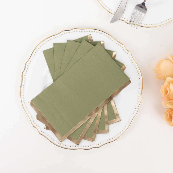 Elegant green napkins with gold accents on a decorative plate.