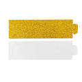 Gold glitter and white cardstock cutouts on a plain background