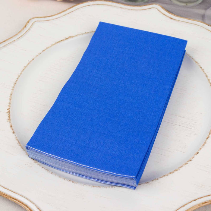 Stack of blue napkins on a decorative plate.