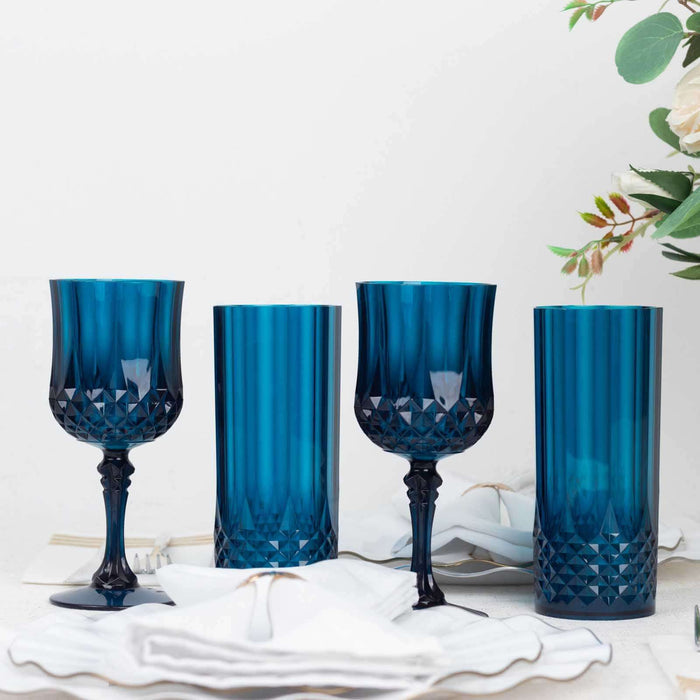 Set of four elegant blue glassware pieces on a table with decor.
