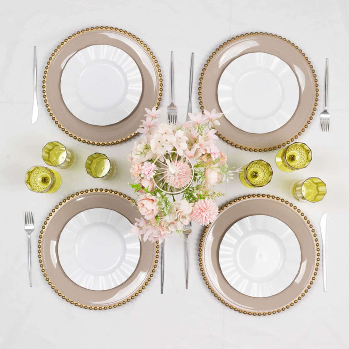 Elegant dining table setting with plates, cutlery, and floral centerpiece.