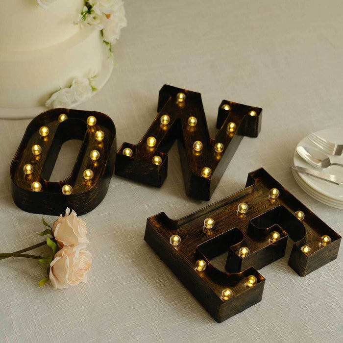Decorative "ONE" light-up letters with gold bulbs on a table.