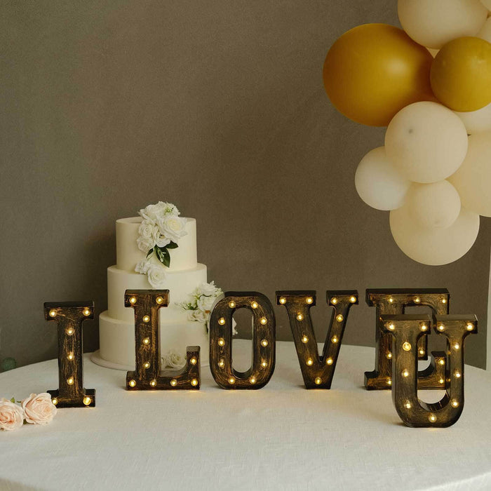 Decorative "I LOVE U" marquee letters with lights at a wedding setting.