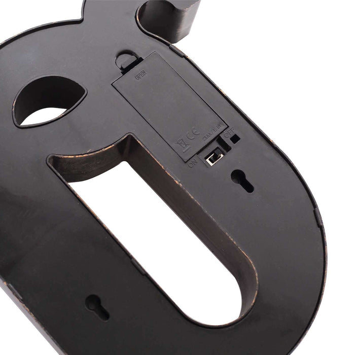 Black decorative letter "P" with cutout design and battery compartment