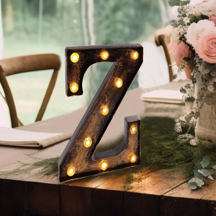 Decorative marquee letter "Z" with lights on a rustic table setting.