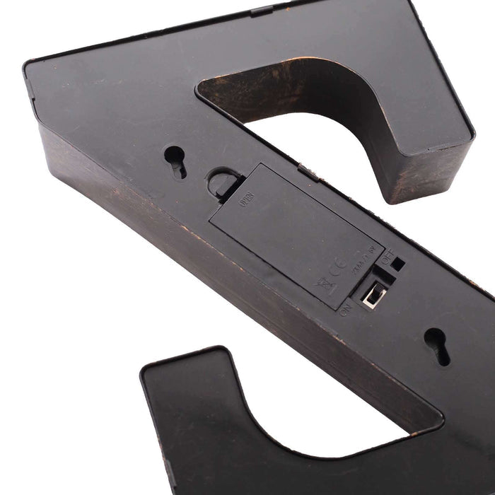 Black decorative letter "Z" with battery compartment on a plain background