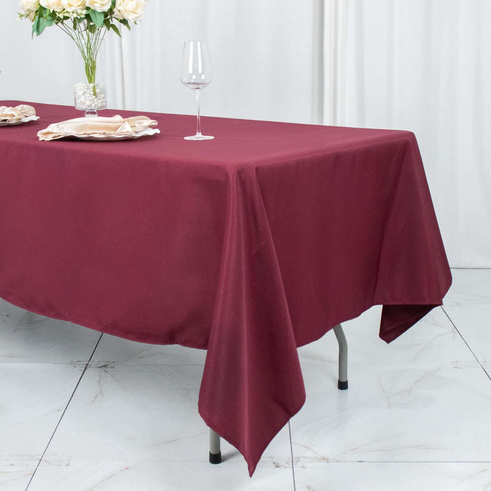 Burgundy tablecloth draped over a dining table with elegant glassware.