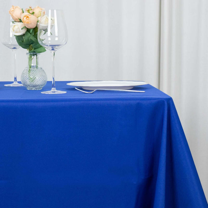 Elegant blue tablecloth with wine glasses and a floral centerpiece.