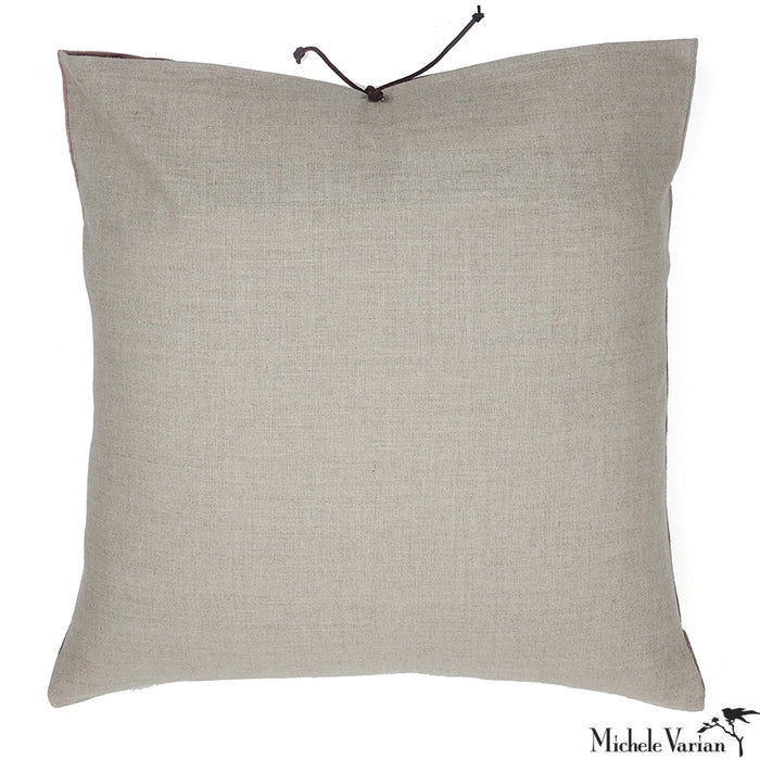 A plain linen backside of a throw pillow with a leather tie closure on a white background.