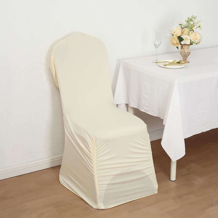 Cream chair cover draped on a chair beside a table with flowers.