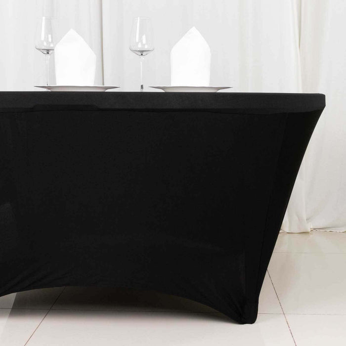 Black table cover with glasses and napkins on a table setting.
