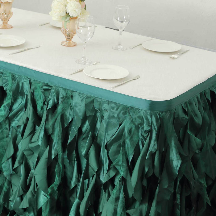 Green ruffled table skirt with elegant table setting.
