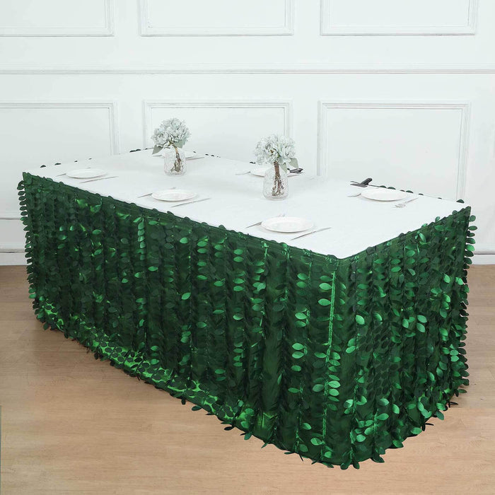 Green leaf table skirt with white table setup and floral centerpieces.