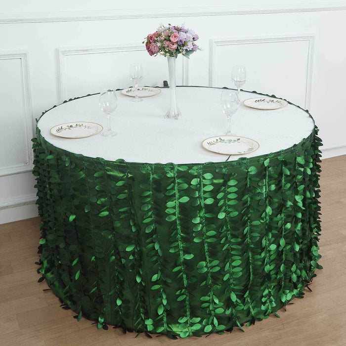 Green leaf table skirt with elegant dining setup and floral centerpiece.