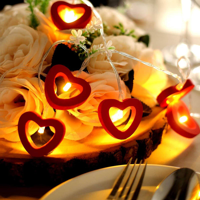 Red heart-shaped string lights on a floral centerpiece.