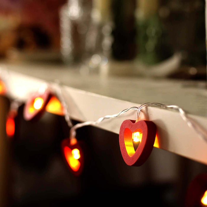 Red heart-shaped fairy lights on a shelf, creating a warm ambiance.